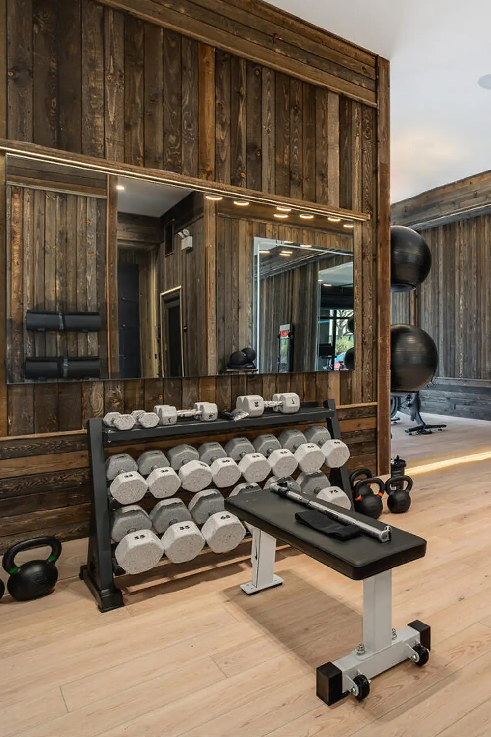 Dumbbell rack and weight bench in a wood-paneled room