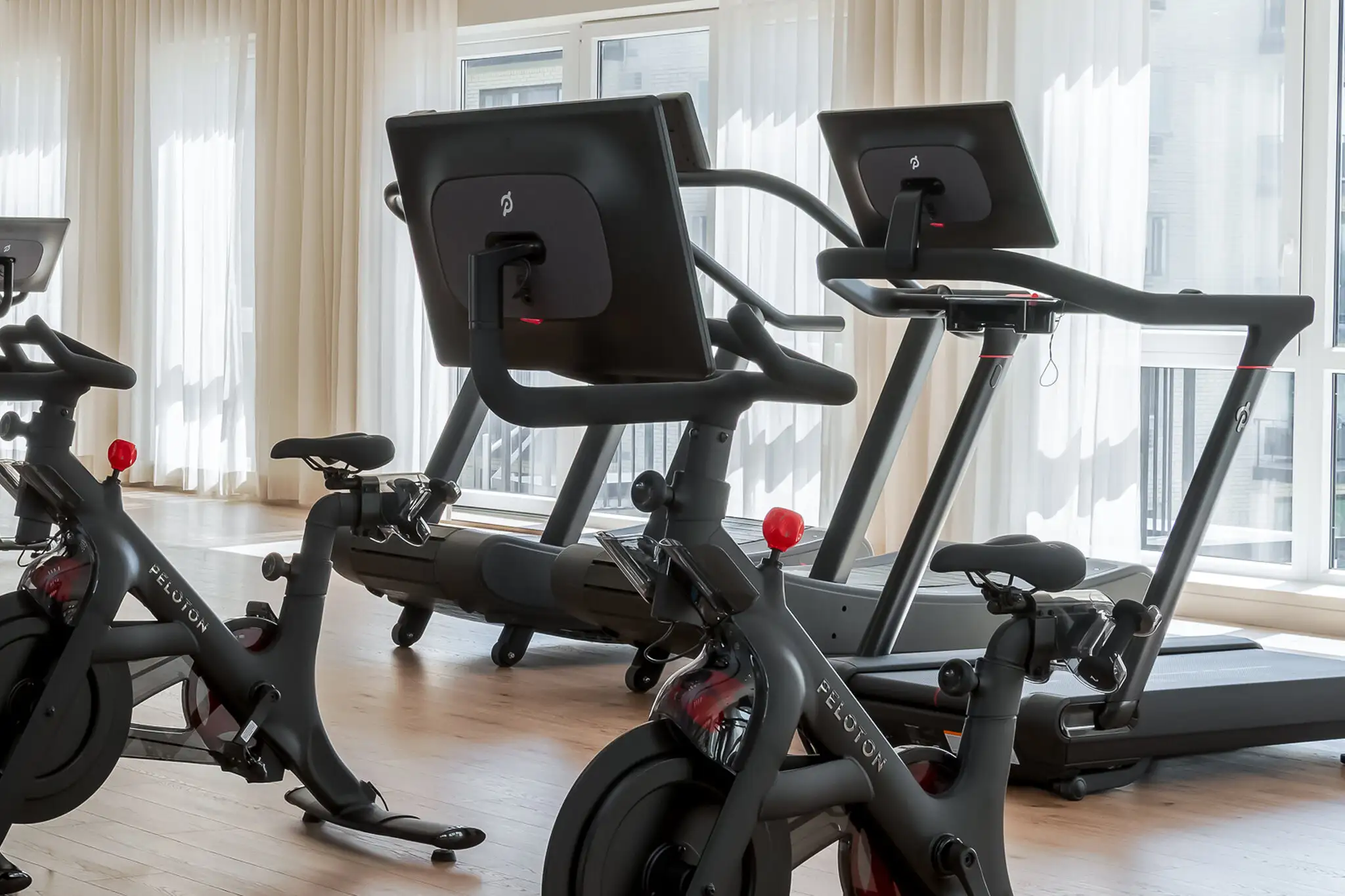 Peloton bikes and treadmills in a bright fitness room