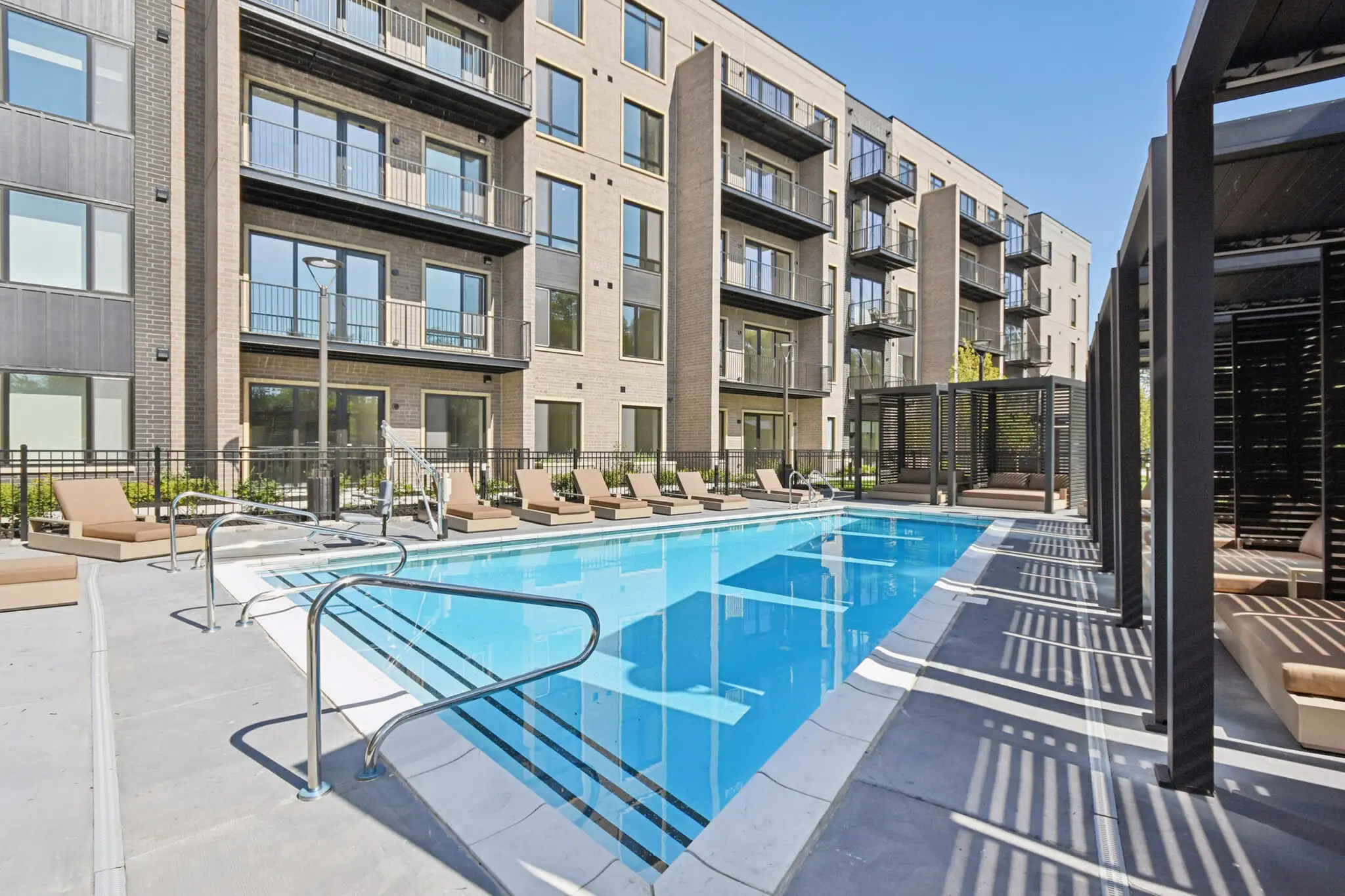 Outdoor pool with a shade pergola and lounge chairs