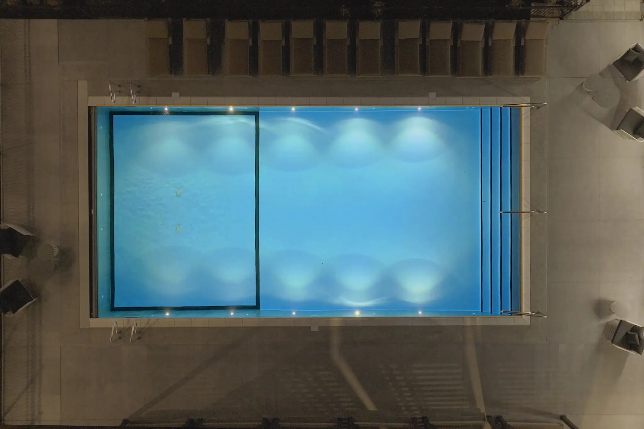 Overhead view of a lit pool at night